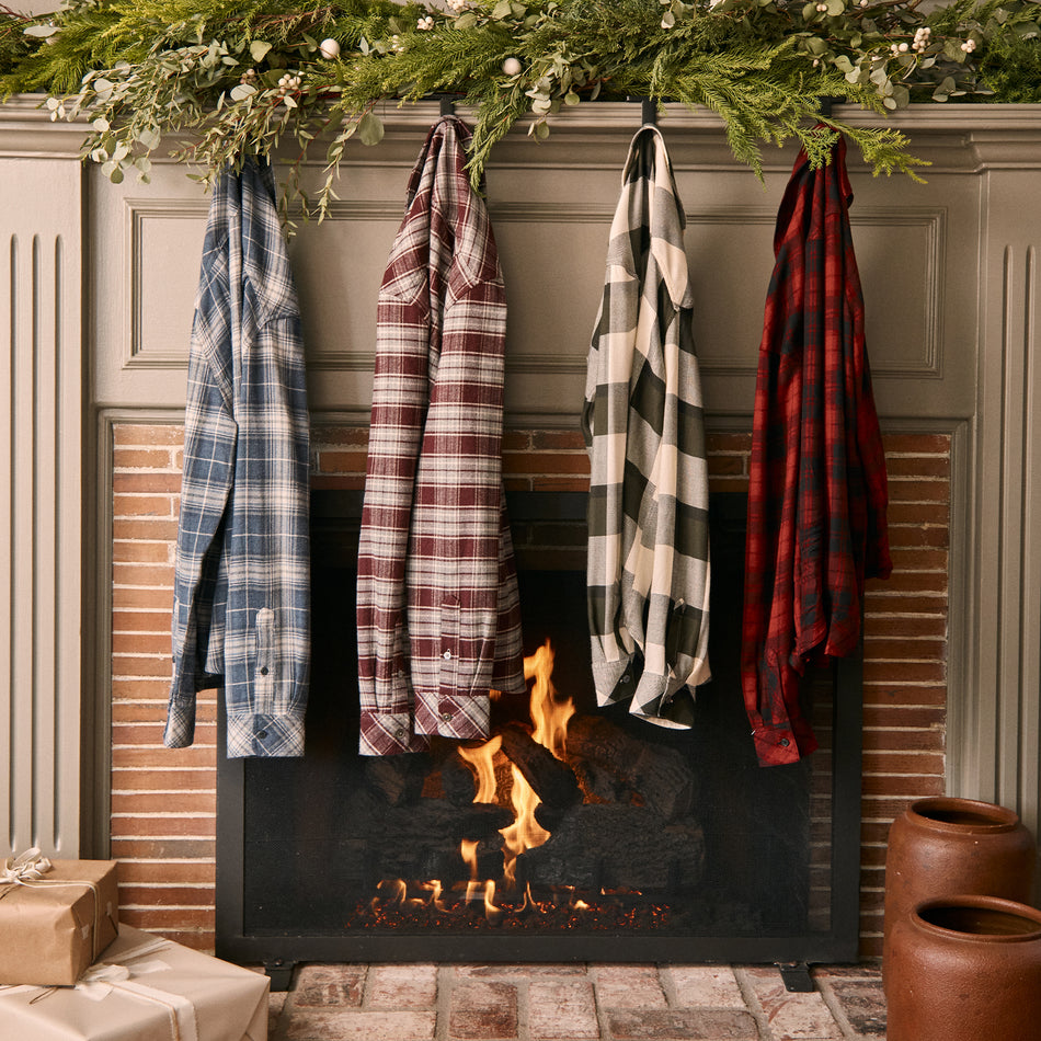 EDITORIAL IMAGE OF MULTIPLE PLAID SHIRTS HUNG ON A FIREPLACE